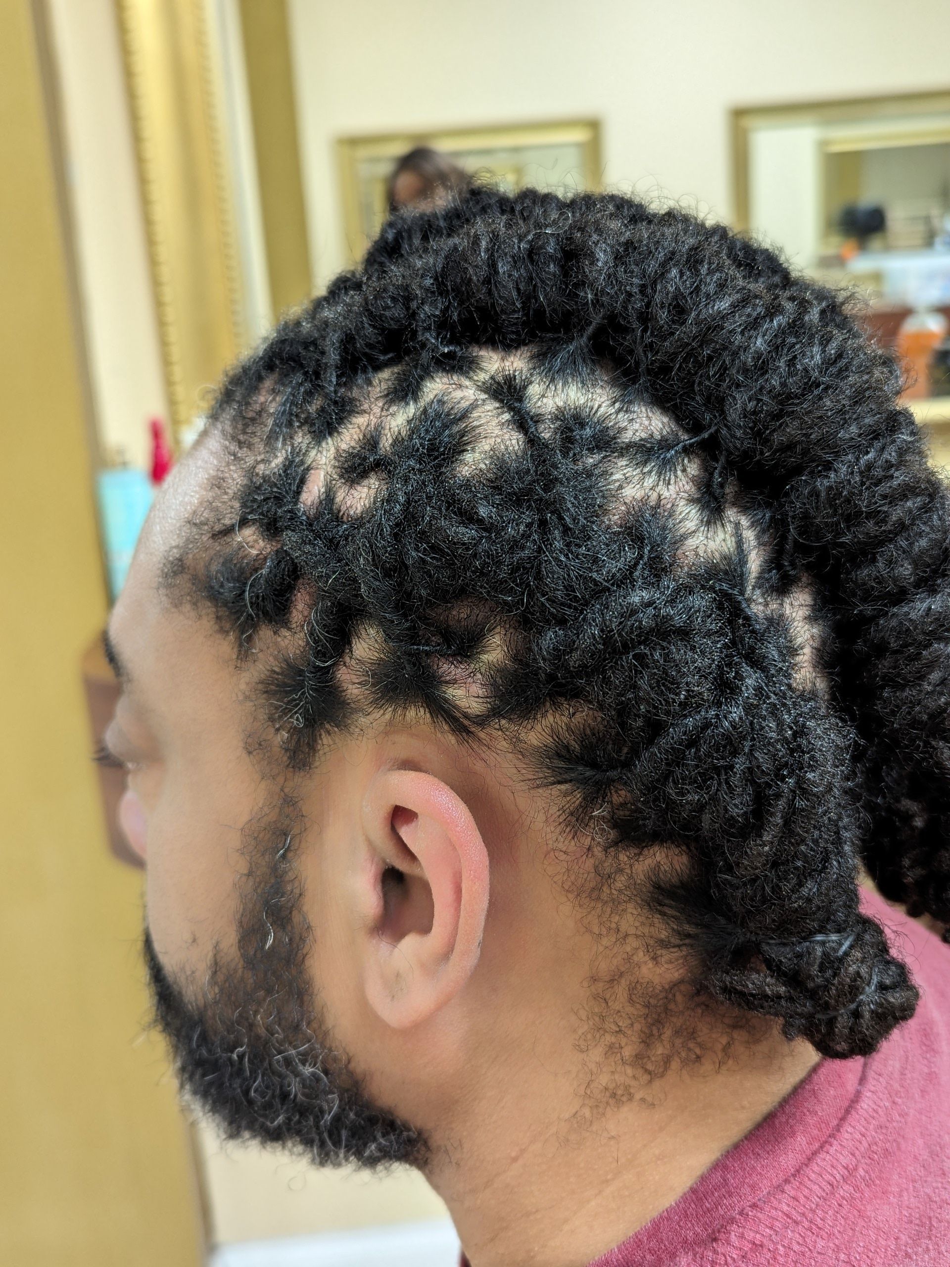 Side view of braided hair with a low bun in a salon setting