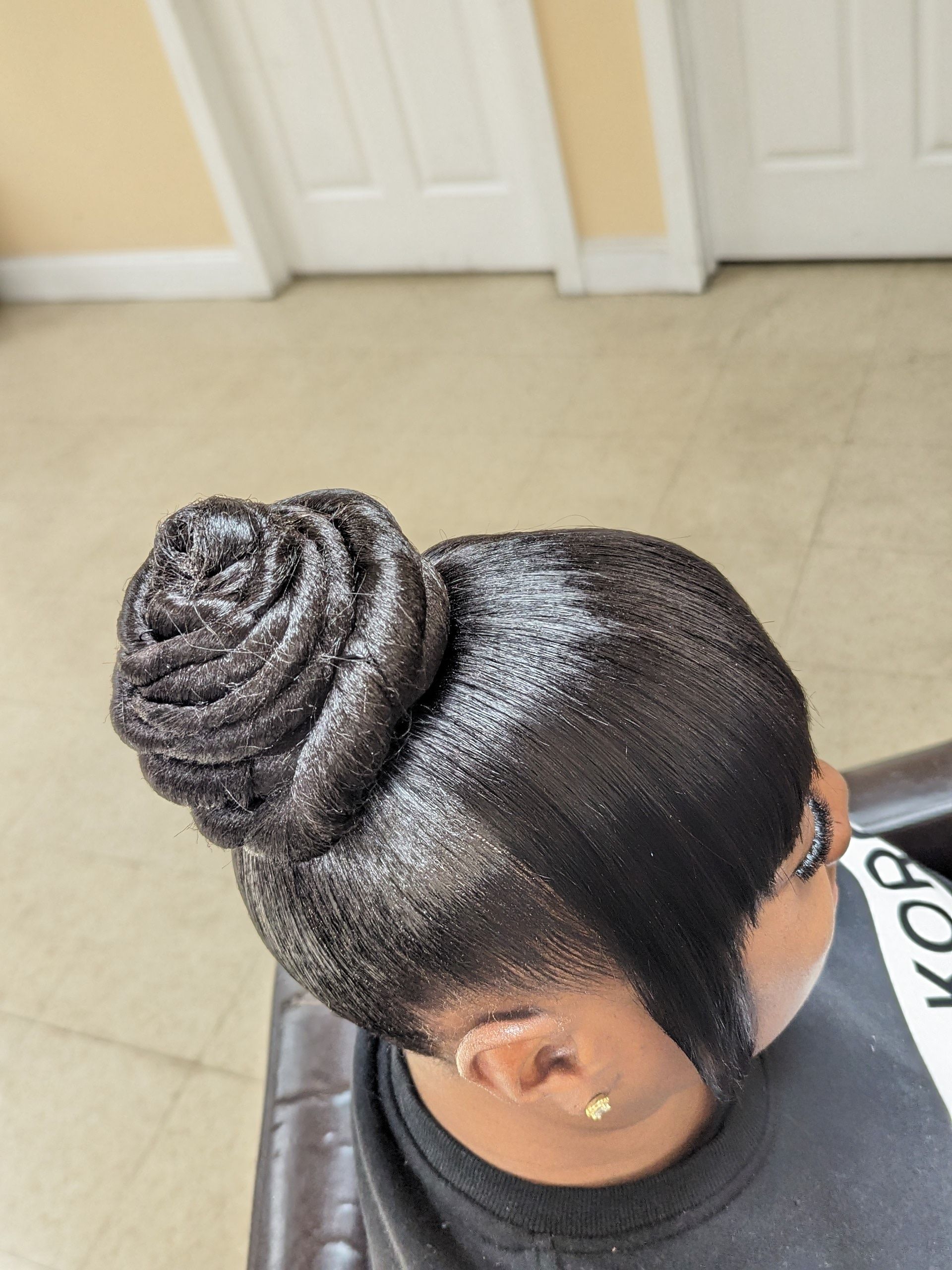 Twisted bun hairstyle on a mannequin head in a salon setting