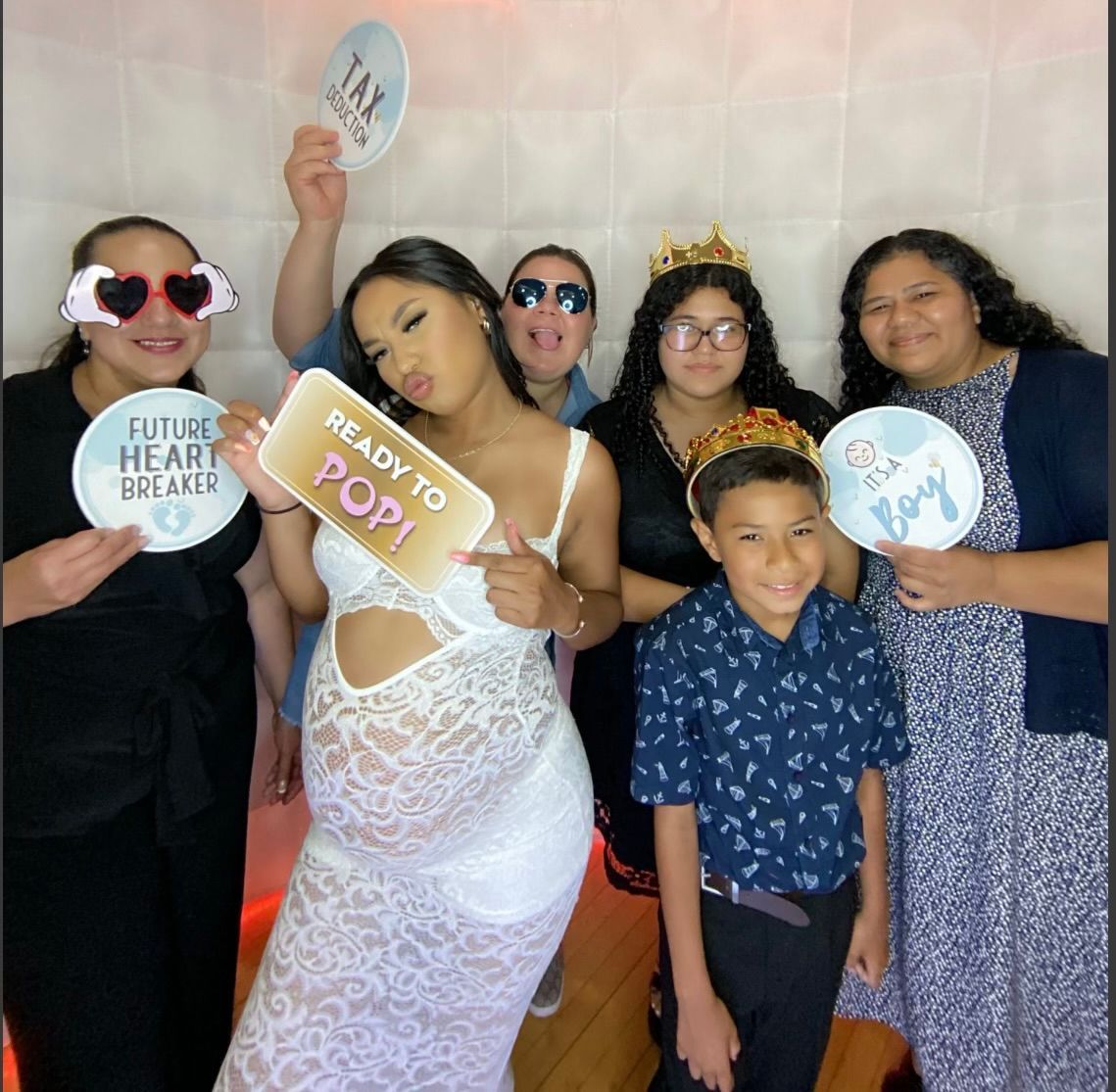 A woman in a white dress is holding a sign that says ready to pop