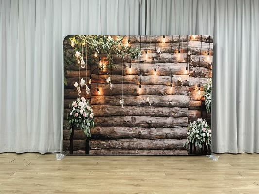 A wooden wall with flowers and lights hanging from it.