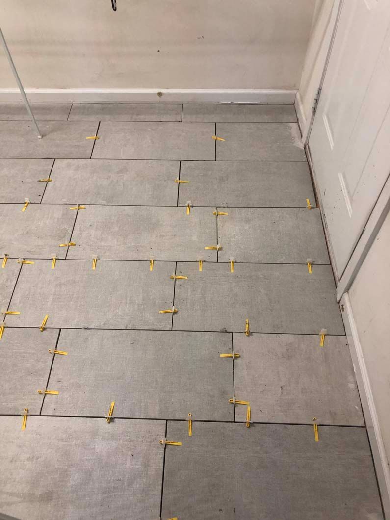 A close up of a tiled floor with yellow spacers.