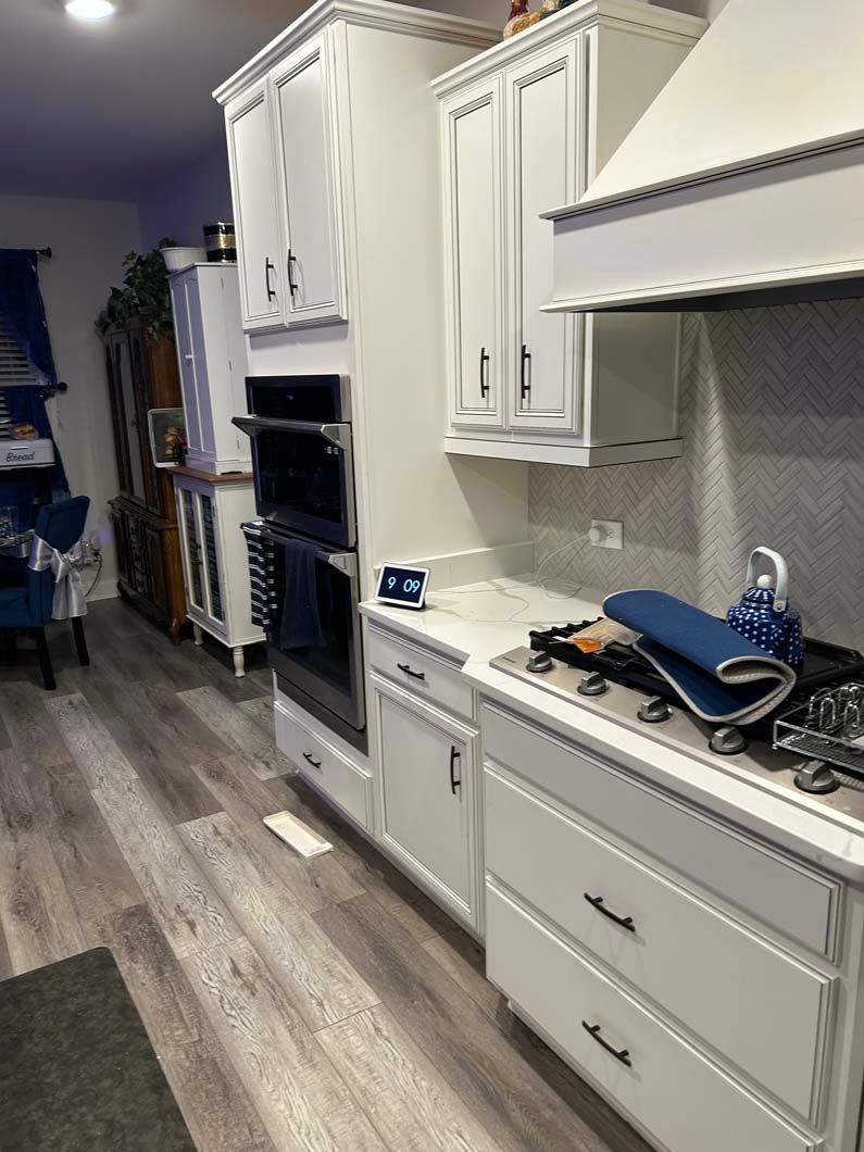 A kitchen with white cabinets and stainless steel appliances.