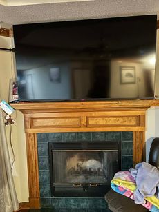 A flat screen tv is mounted above a fireplace in a living room.