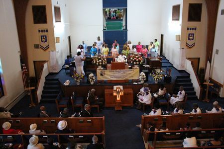 Congregation seated in a church sanctuary during a service, with the altar centered at the front.