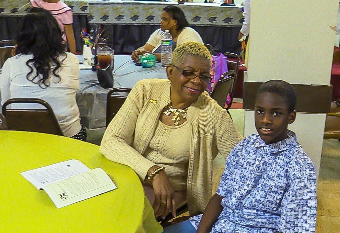 Two people seated at a yellow table in a casual indoor gathering room