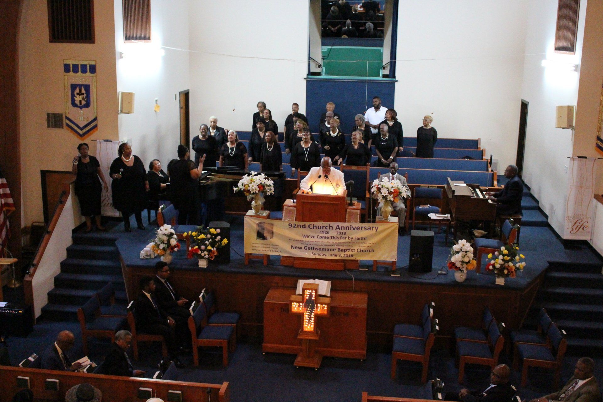 Church sanctuary with congregation seated and choir standing behind the altar during a service