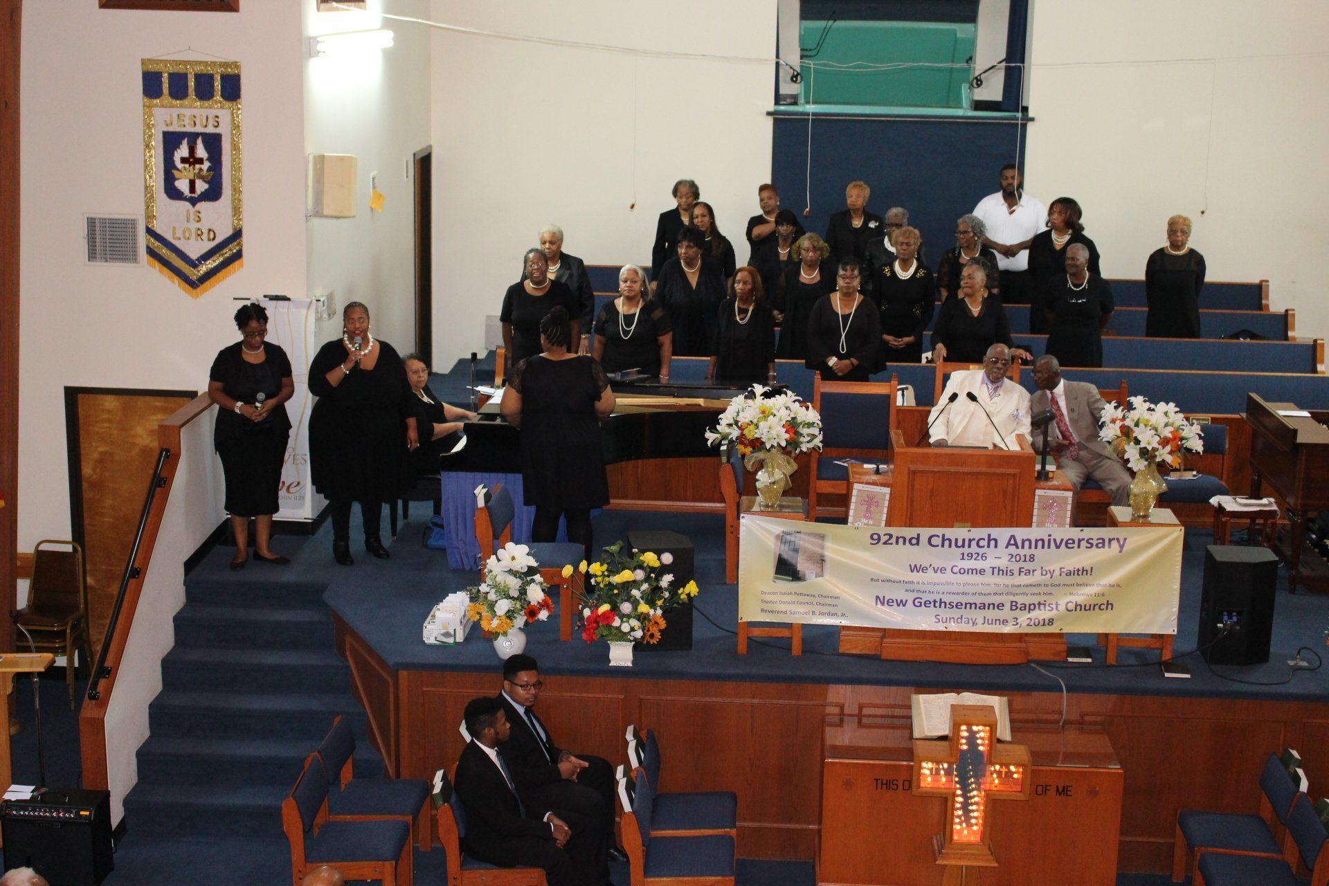 Mourners gathered in a church sanctuary around a flower-covered casket during a memorial service