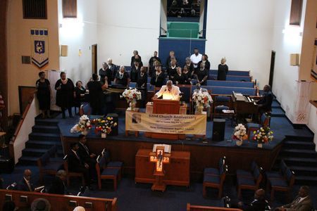 Congregation gathered in a church sanctuary around a central altar during a service