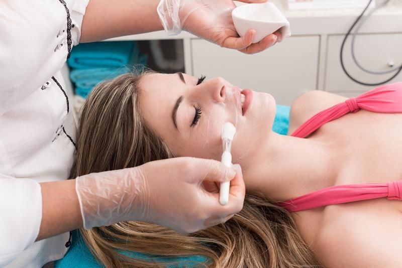 A woman is getting a facial treatment at a beauty salon.
