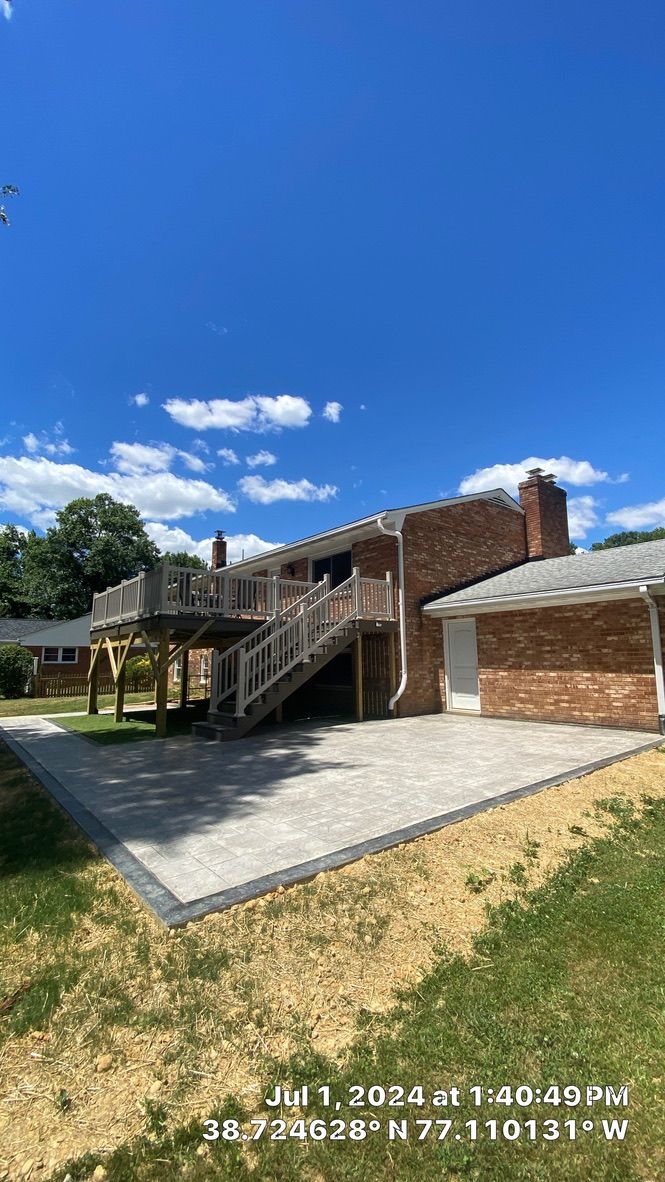 Low brick building with exterior stairs and white trim under a bright blue sky