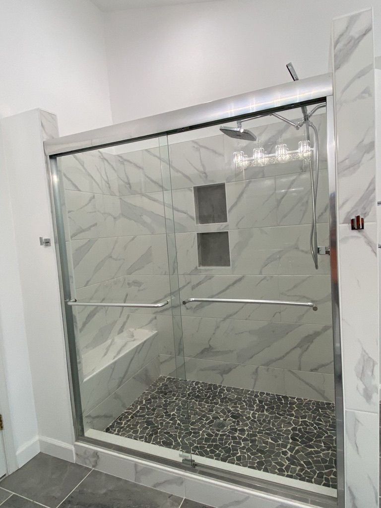 Empty stainless-steel elevator cabin with a patterned floor in a white hallway