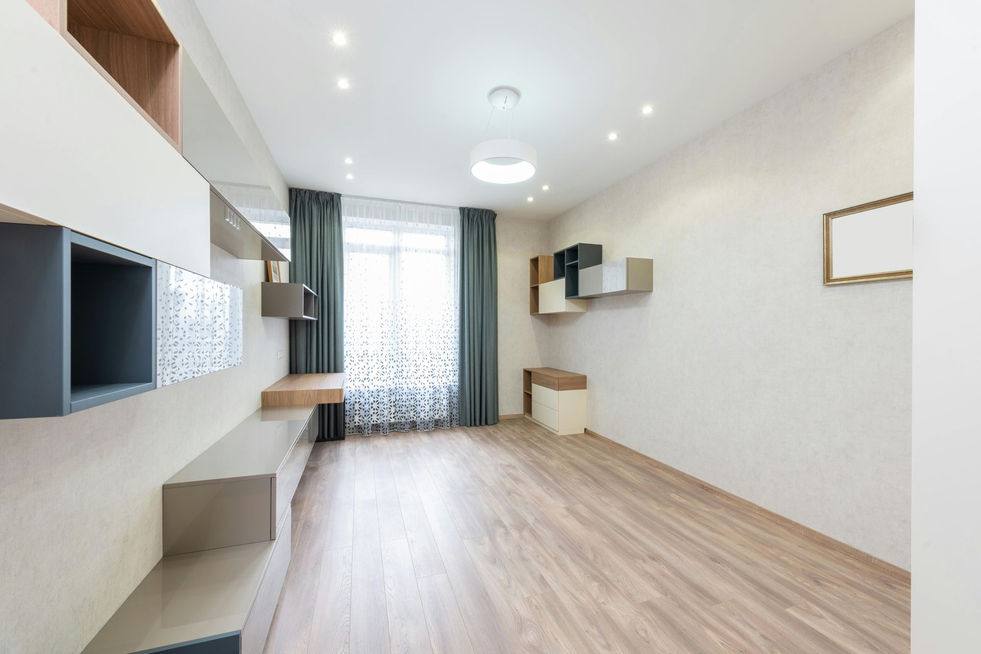 Bright modern living room with light wood floors, wall-mounted shelves, and large window curtains