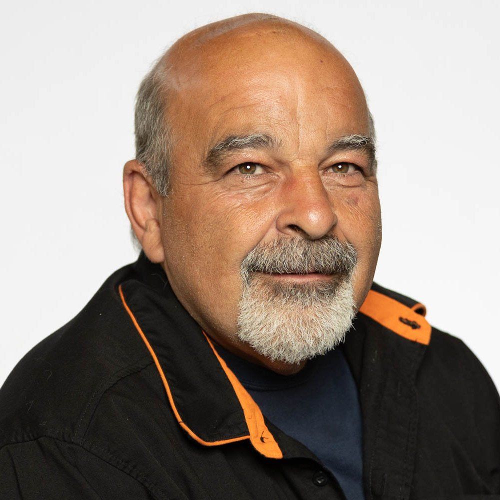 A bald man with a beard wearing a black jacket