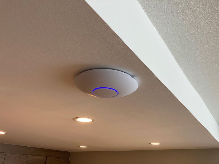 Technician mounting a ceiling wireless access point