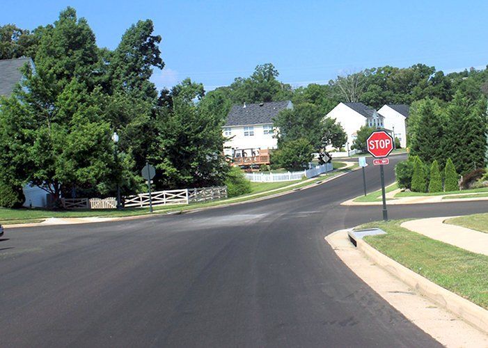 a newly paved intersection with sanding present before sweeping and wear in