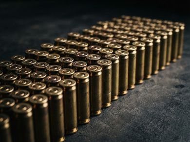 Rows of brass bullet cartridges lined up diagonally on a dark surface