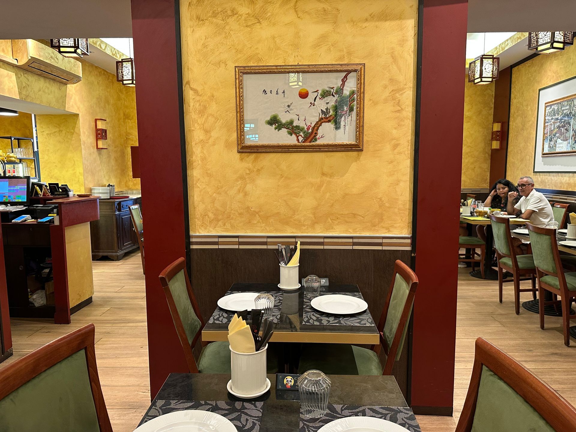 Sala da pranzo di un ristorante con una tavola apparecchiata e commensali seduti sullo sfondo