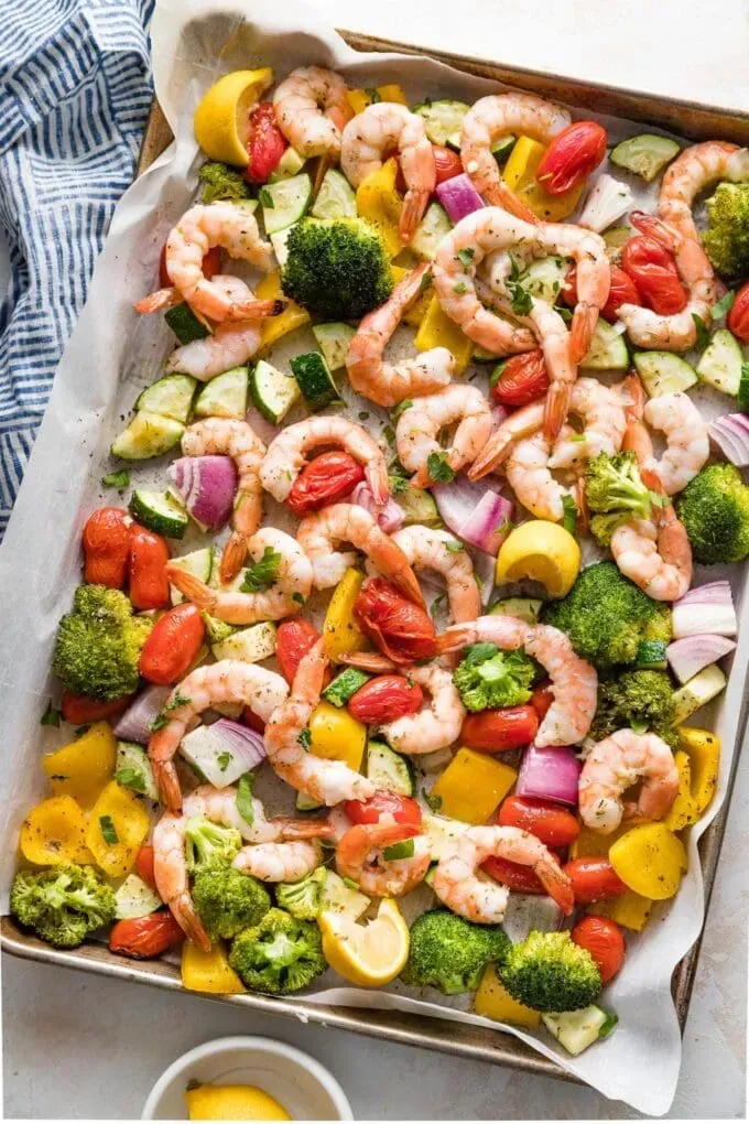 A pan filled with shrimp and vegetables on a table.