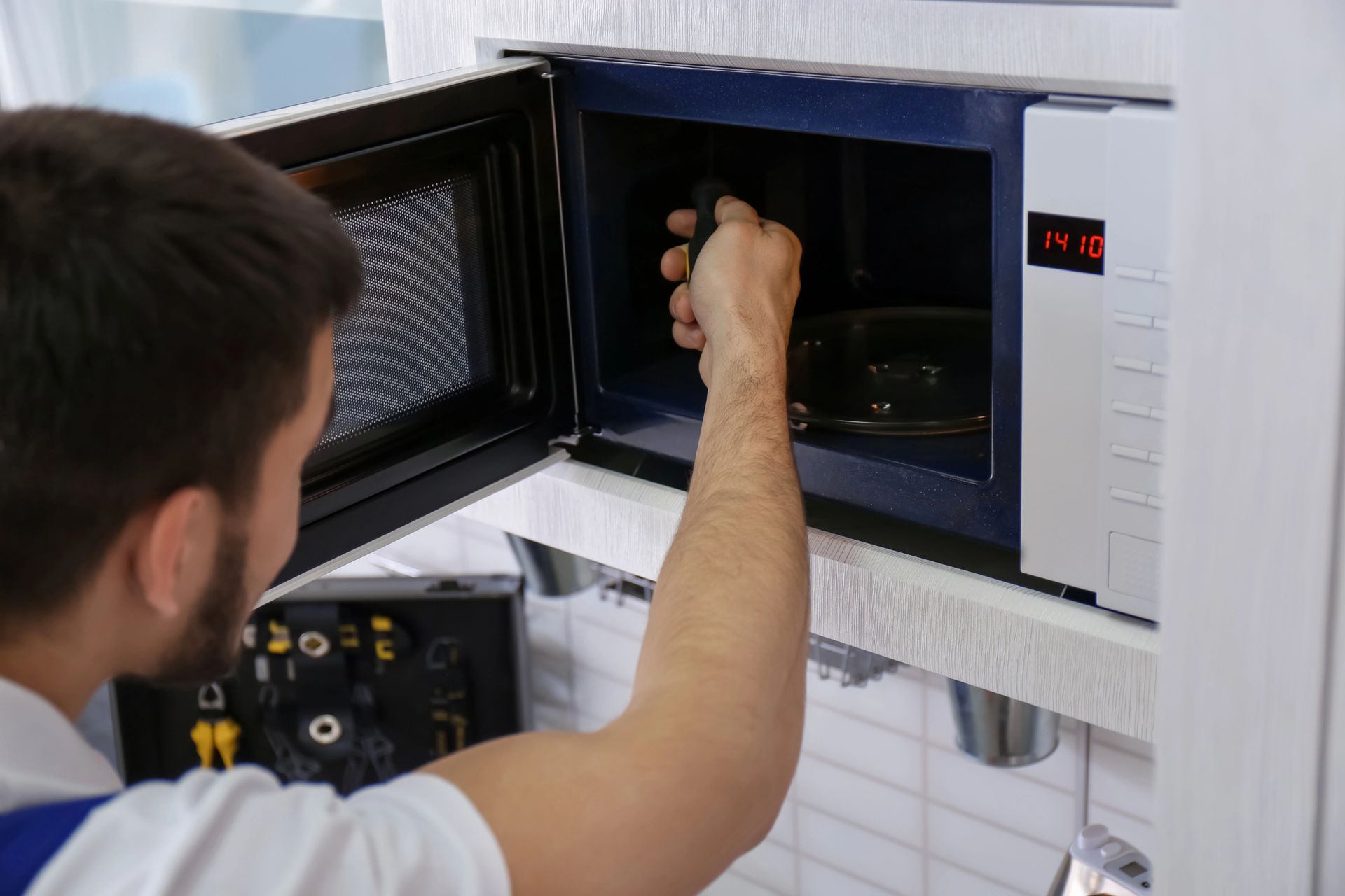 Persona colocando una muestra en un horno microondas de laboratorio abierto