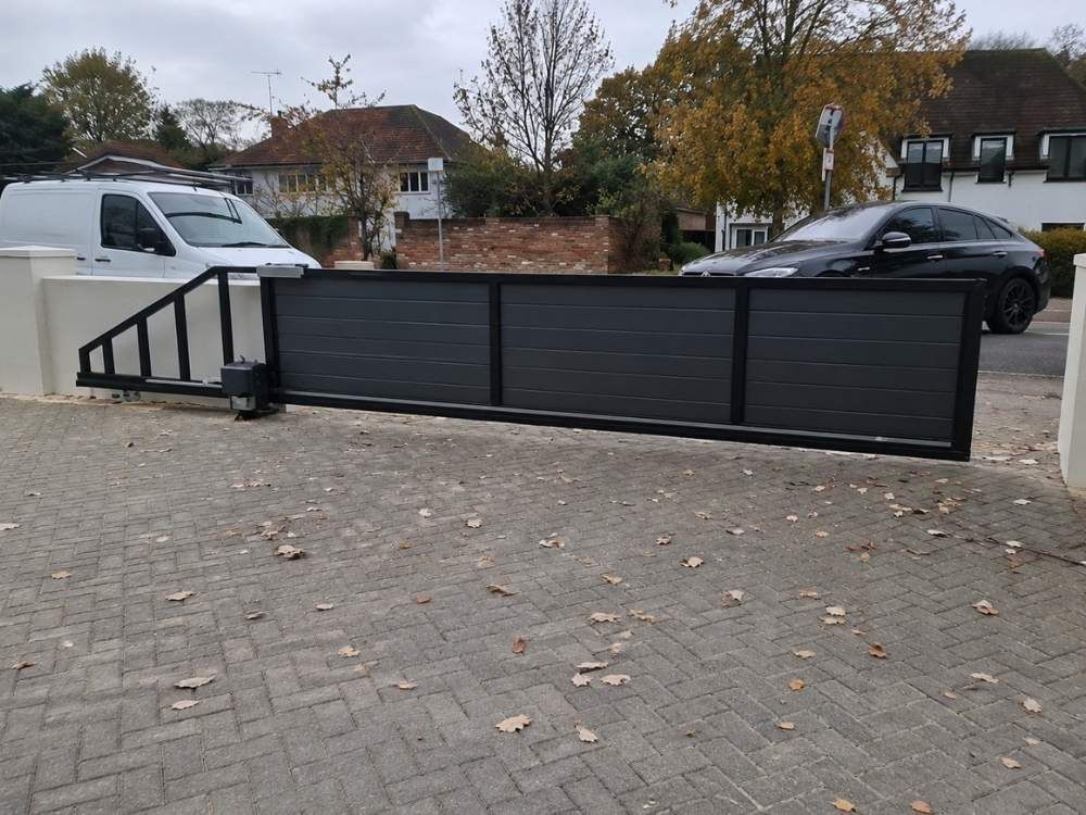 Cantilever sliding gate closed across a driveway entrance with no ground track visible