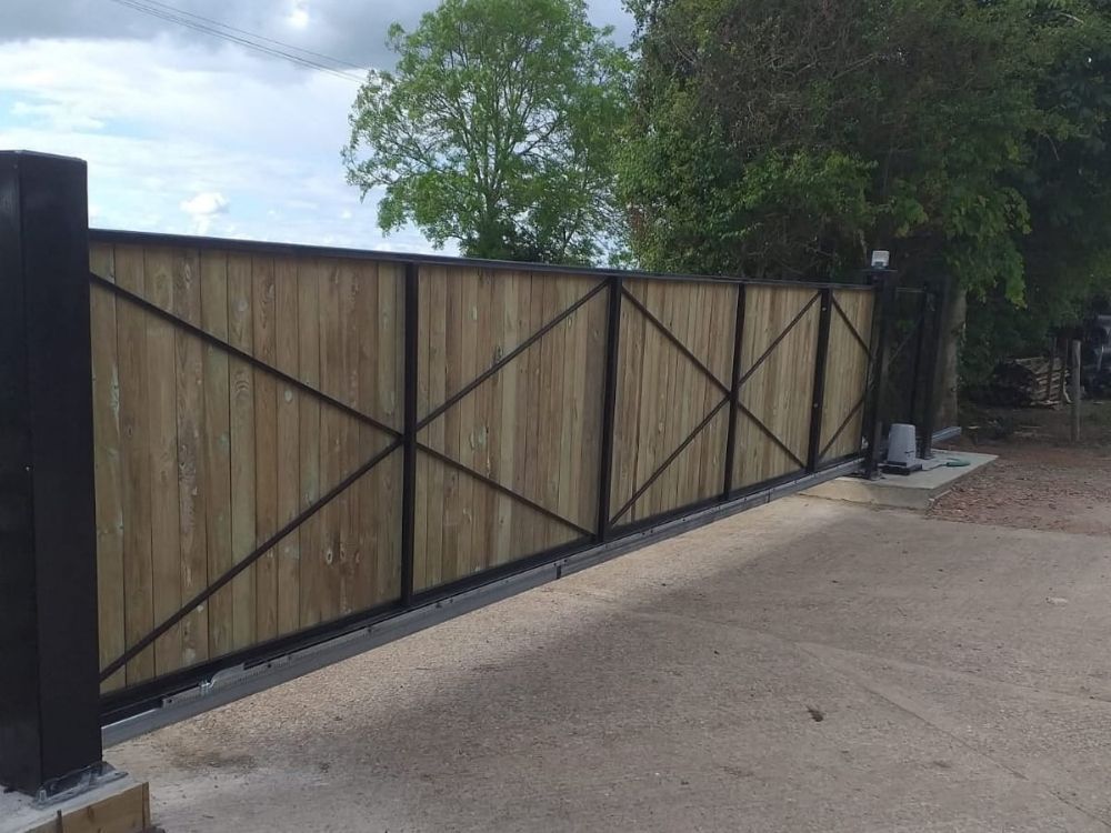 Electric gates with black composite infill panels and steel frame at a private driveway