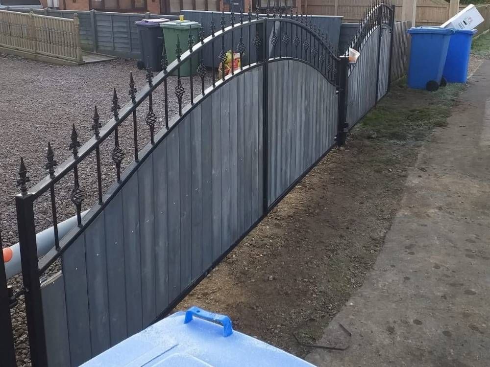 Black metal railings and boundary fencing along a pavement at a new-build development