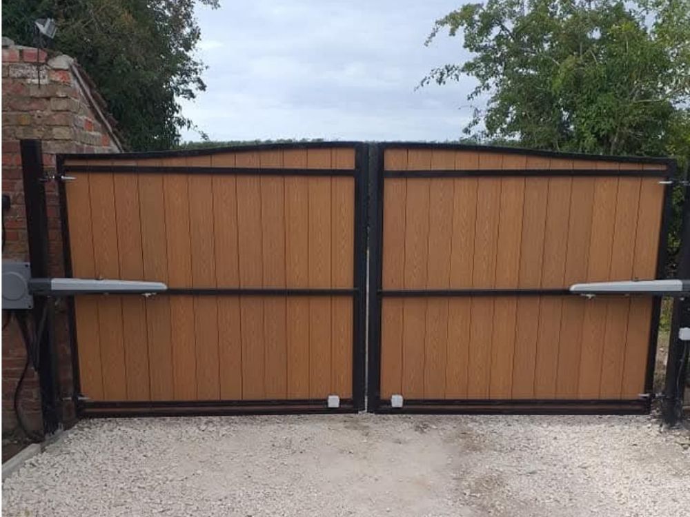 Electric swing gates with oak timber infill and black steel frame fitted with ram arm openers