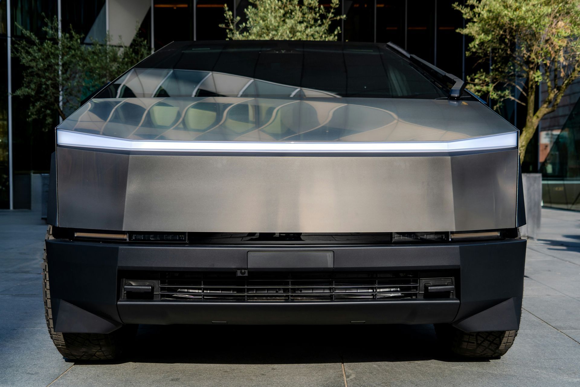 A tesla cybertruck is parked in front of a building.