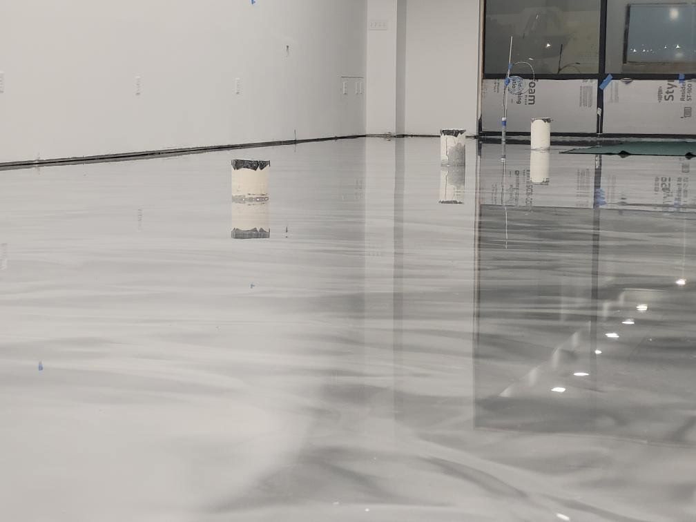 A room with a white floor and a reflection of a window.