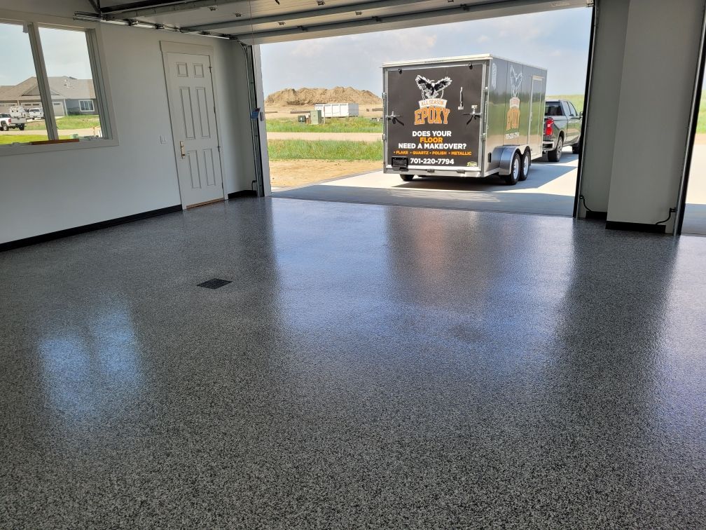 A trailer is parked in a garage with the door open.