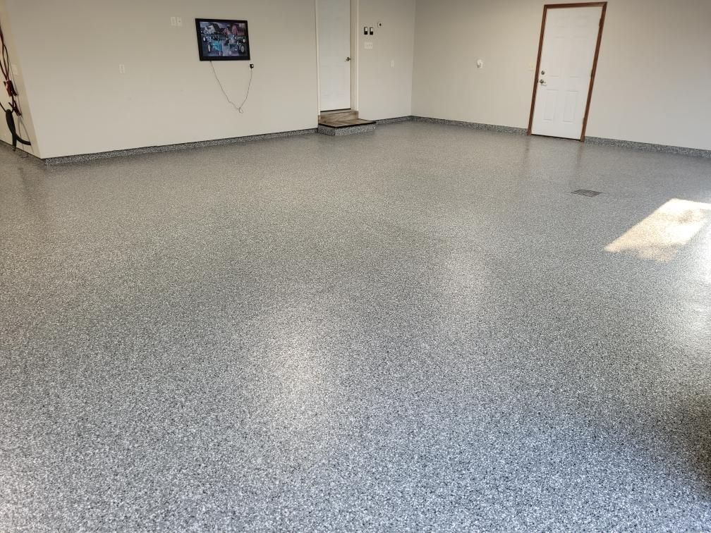 A garage with a gray floor and a white door.