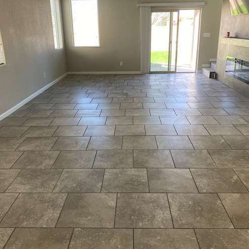 A living room with a tiled floor and a fireplace.