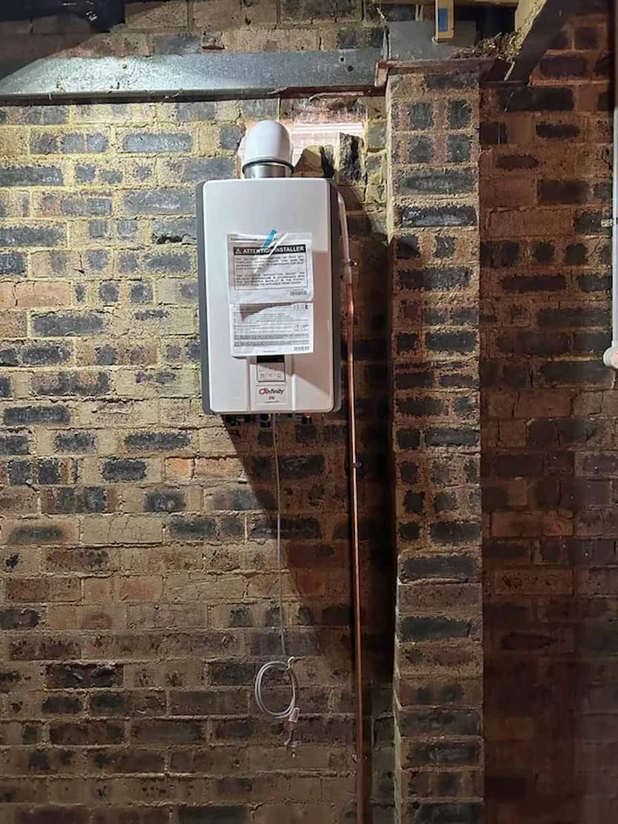 White Wall-mounted Boiler on a Brick Basement Wall — The Plumbing & Drainage Co. in Campbelltown, NSW