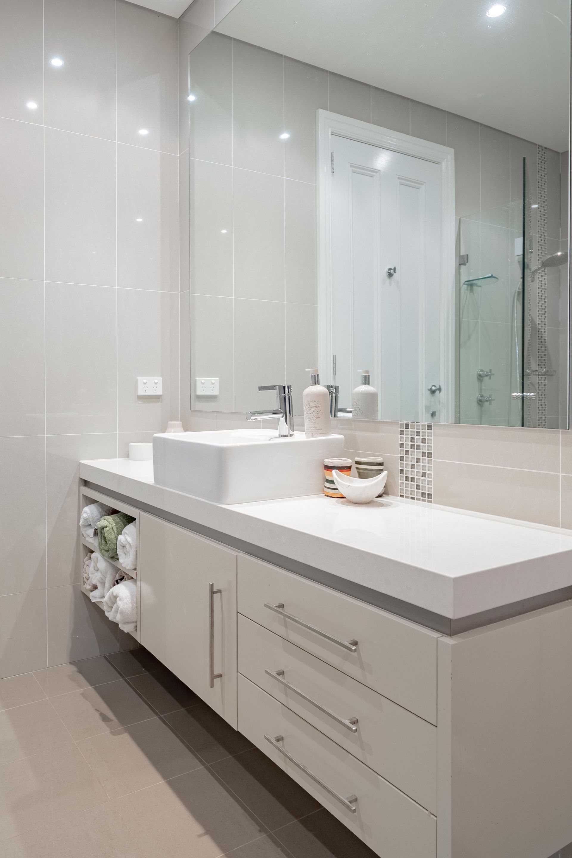 Modern bathroom vanity with large mirror, white sink, and gray cabinetry under bright lighting — The Plumbing & Drainage Co. in Mittagong, NSW