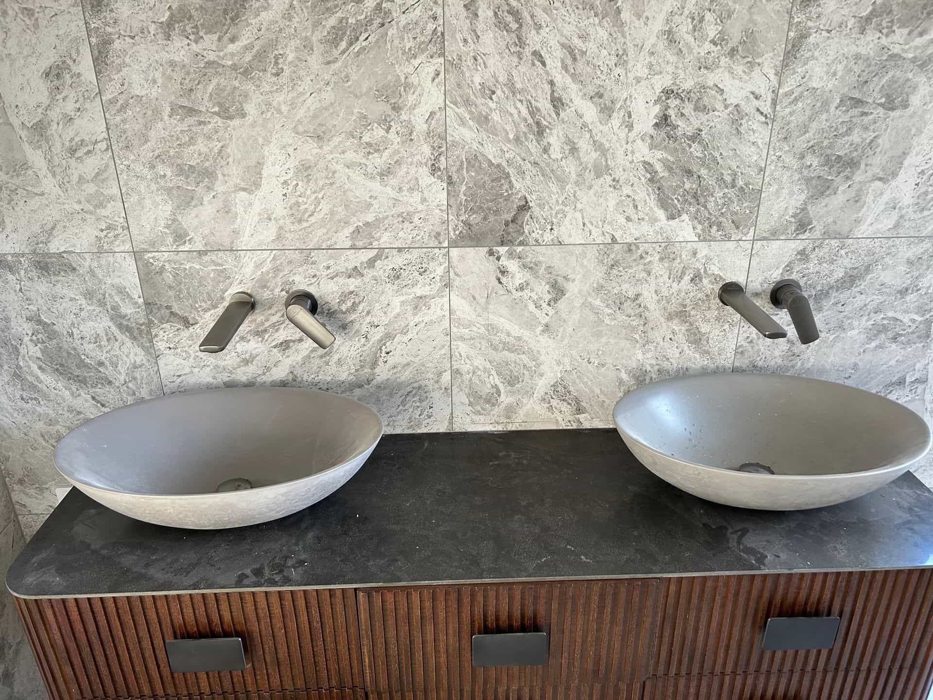Two Gray Vessel Sinks on a Dark Countertop — The Plumbing & Drainage Co. in Southern Highlands, NSW