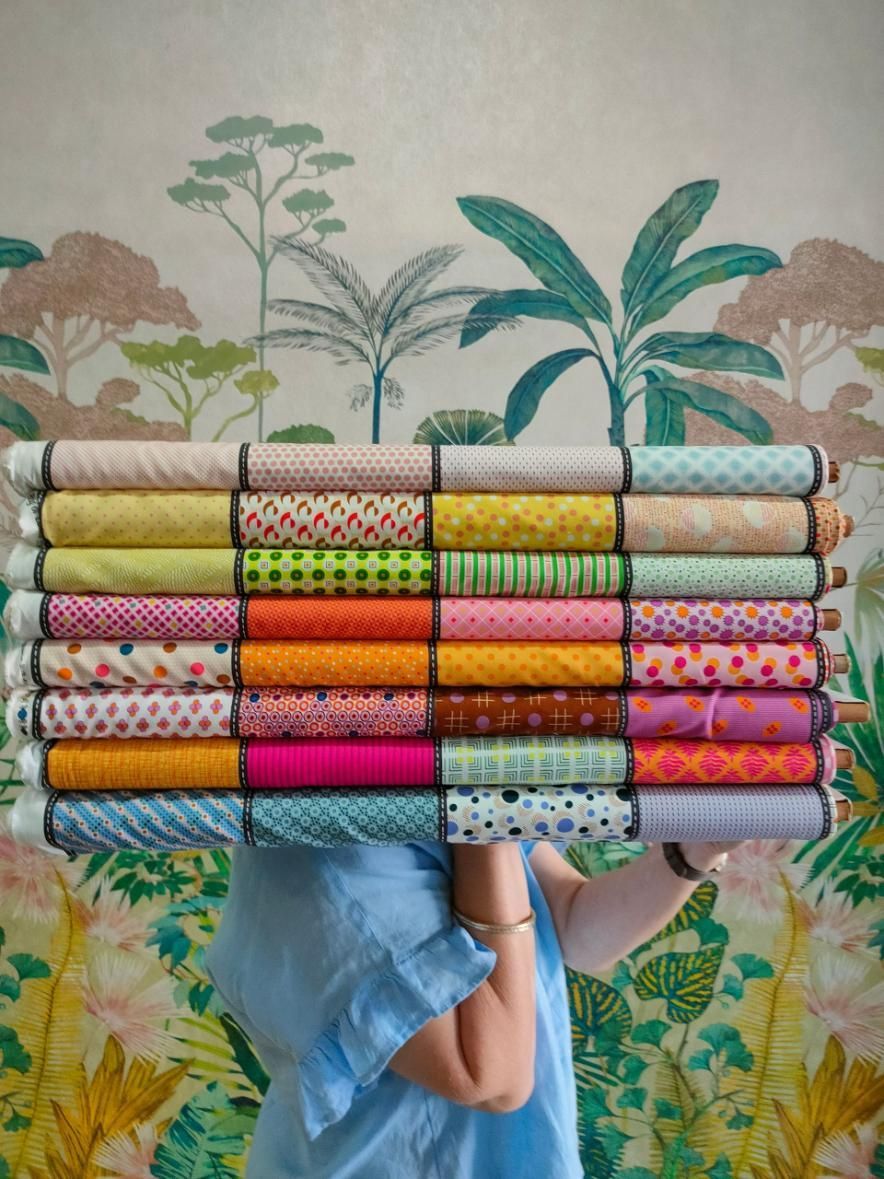 A Woman Is Holding a Stack of Fabric Rolls in Front of Her Face — Stitch 2340 In Armidale, NSW