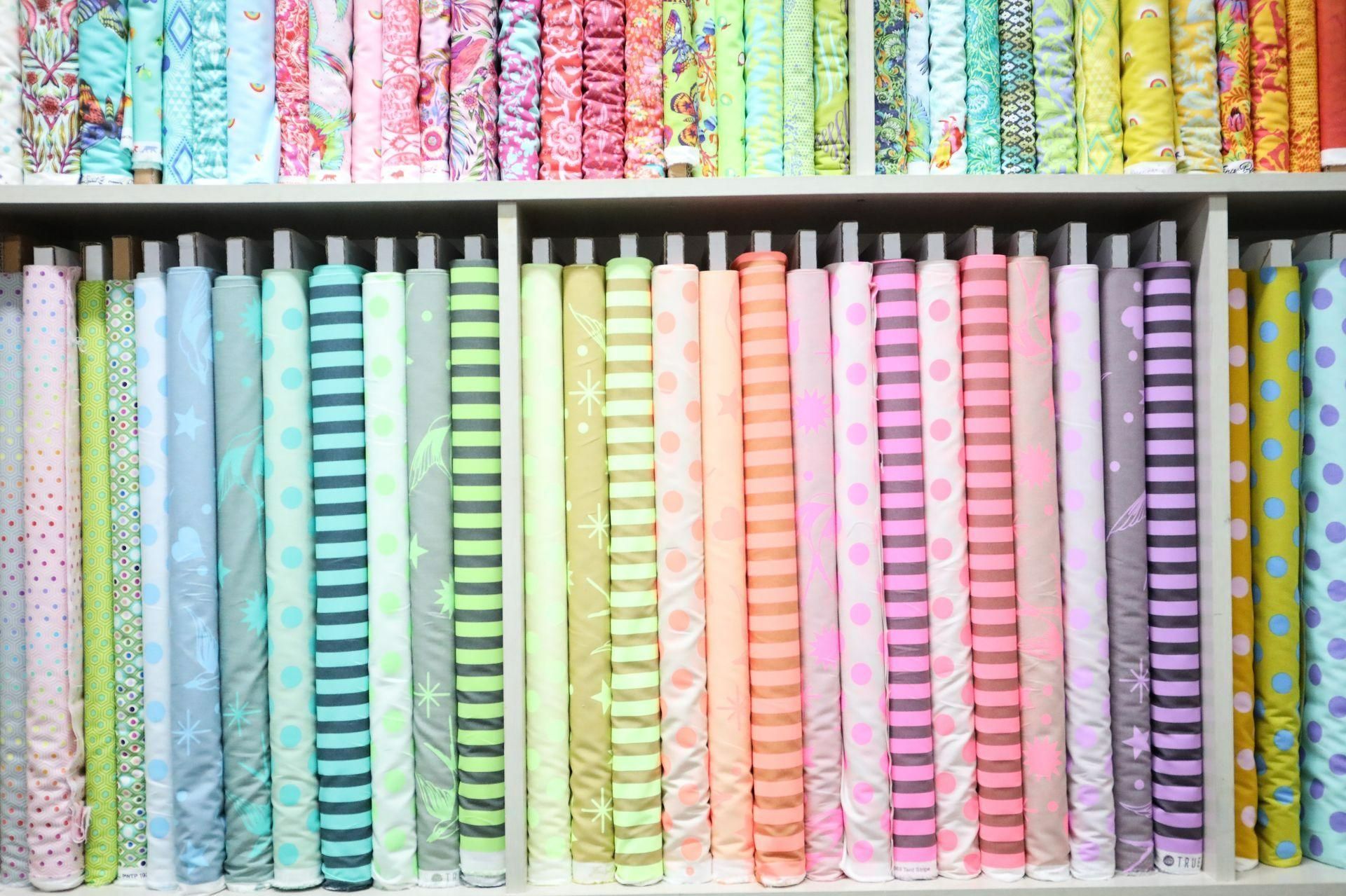 A Shelf Filled with Rolls of Colorful Fabric — Stitch 2340 In Taree, NSW