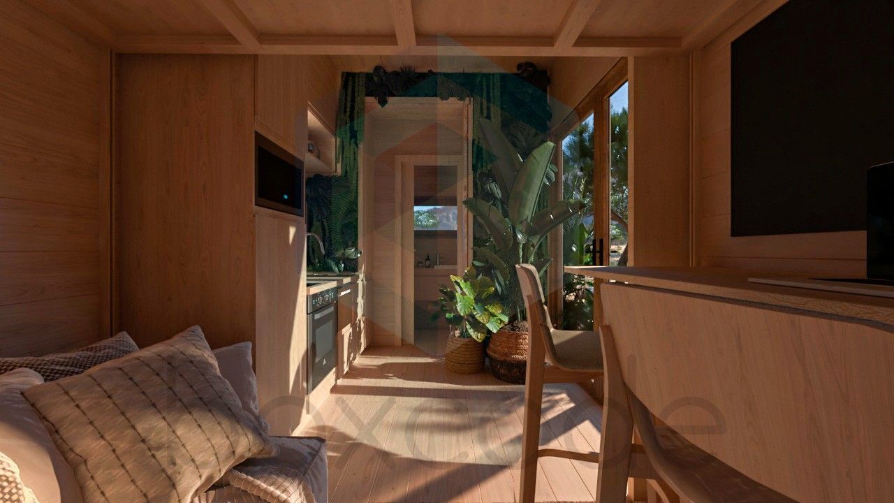 Cozy cabin interior with wood paneling, sunlight, a kitchen, and a view of lush greenery.