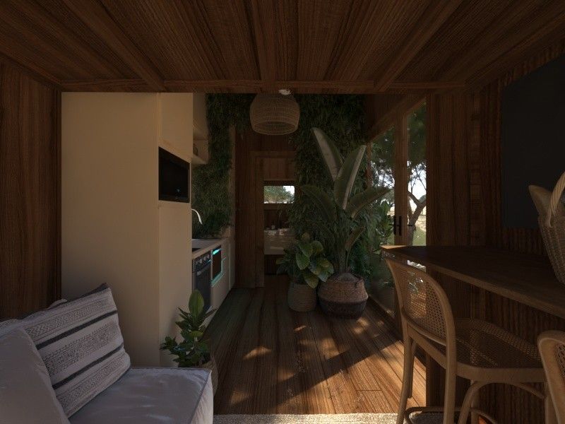 Cozy cabin interior with kitchen, living area, and outdoor views through a lush opening.