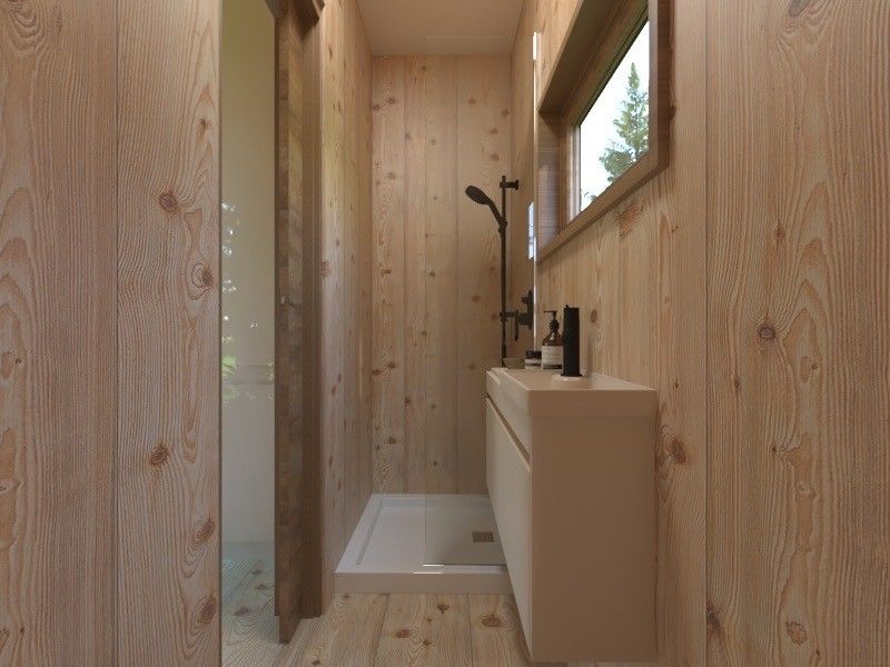 A small, light-wood paneled bathroom. Shower on the left, vanity with window and toiletries on right.