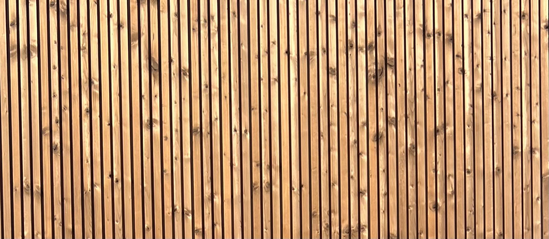 Wooden fence made of vertical, light brown slats.