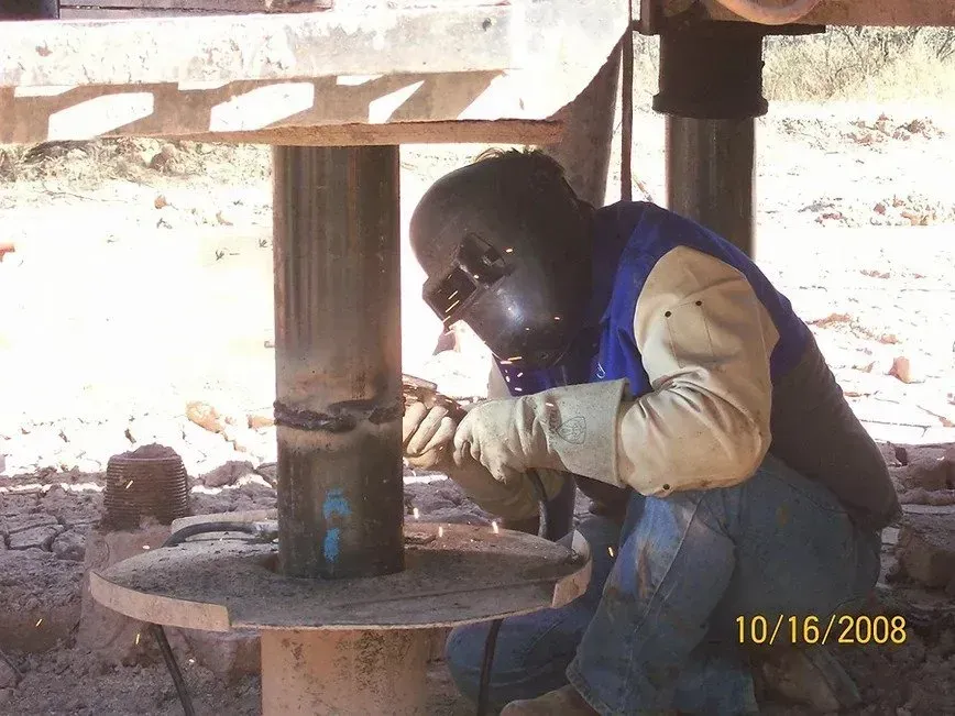a man wearing a welding helmet is working on a piece of metal
