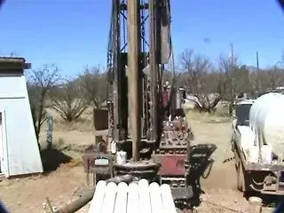 a large machine is drilling a hole in the ground in a field .