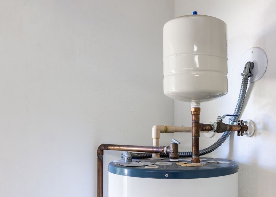 A water heater with a tank attached to it is sitting in a room.