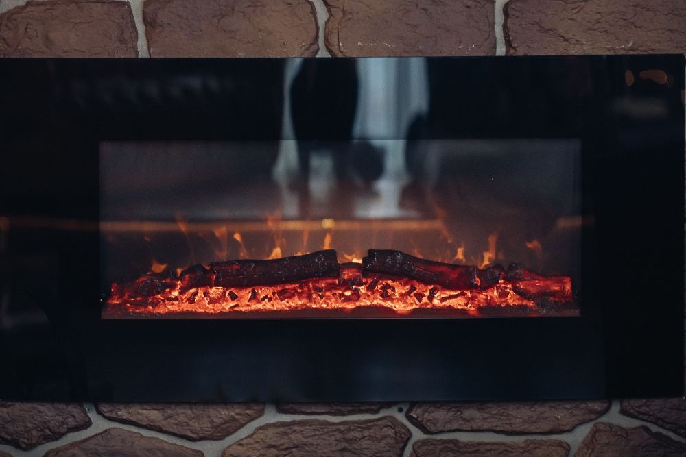 There is a fireplace with a lot of fire in it.