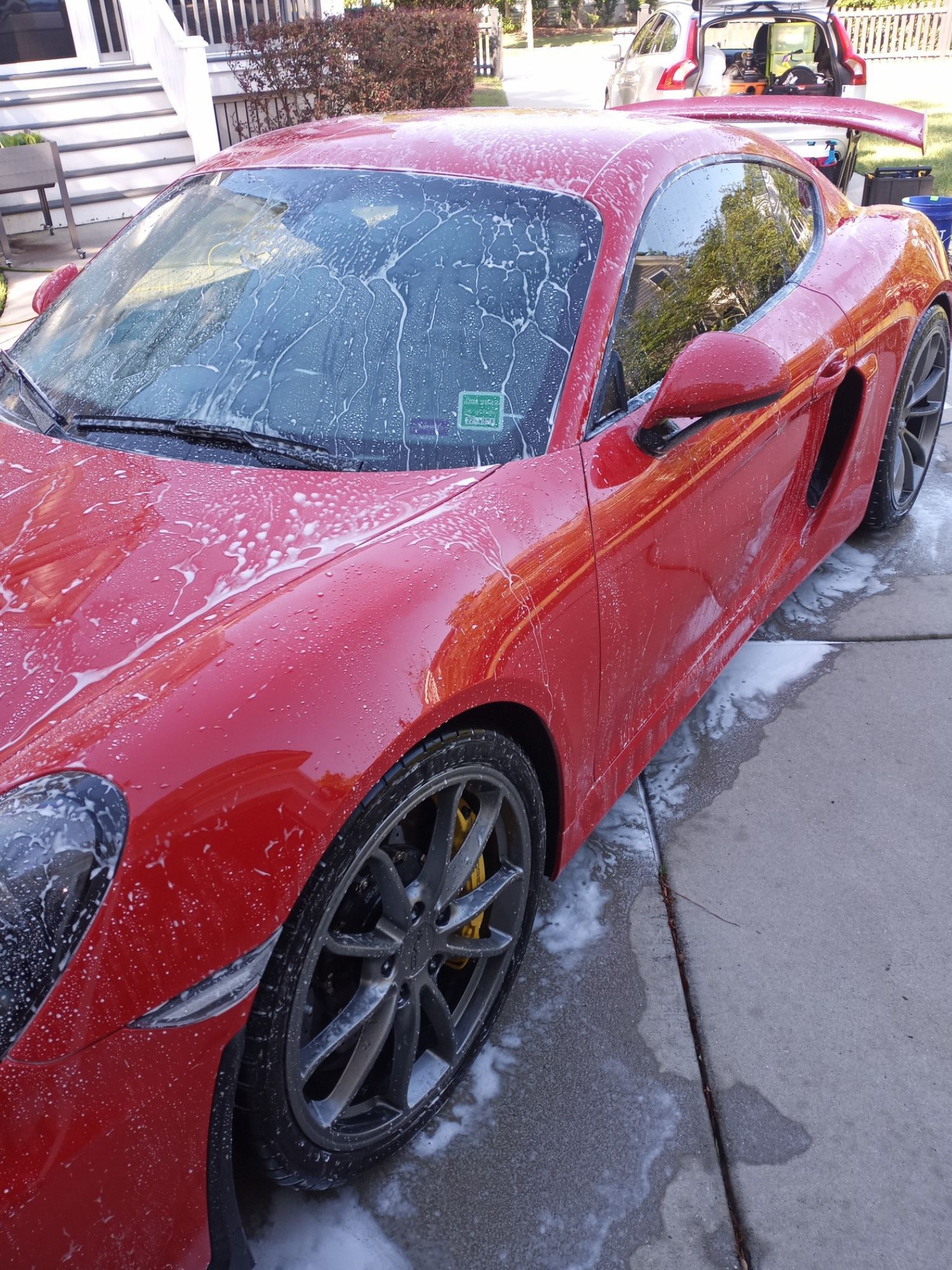 A red sports car is parked on the side of the road.