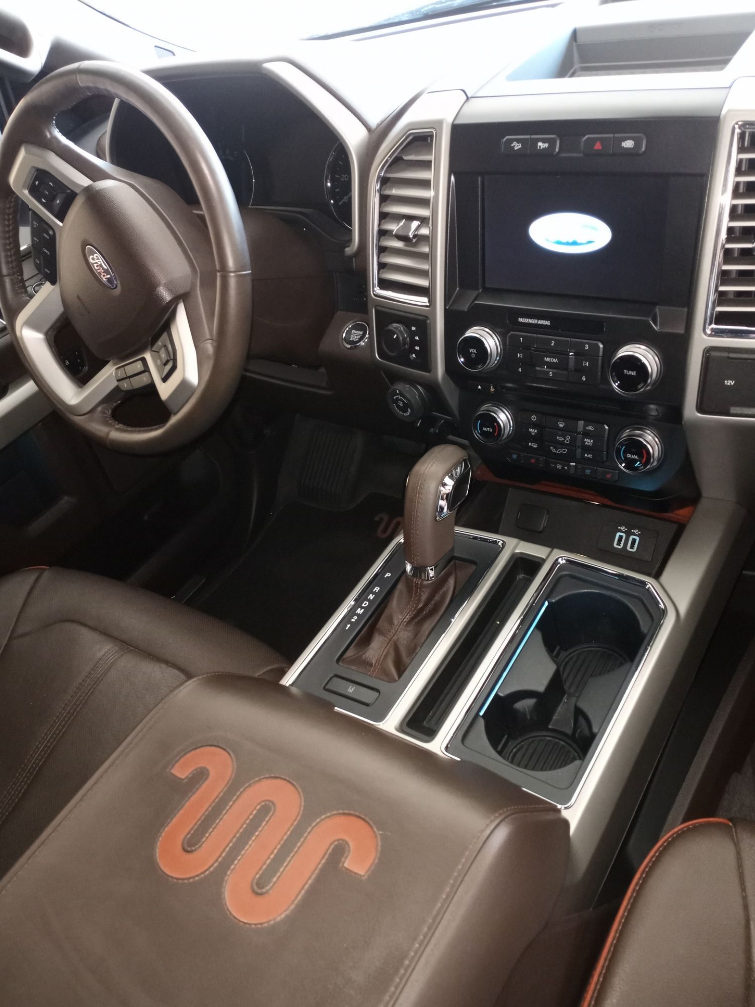The interior of a ford truck with a snake on the center console