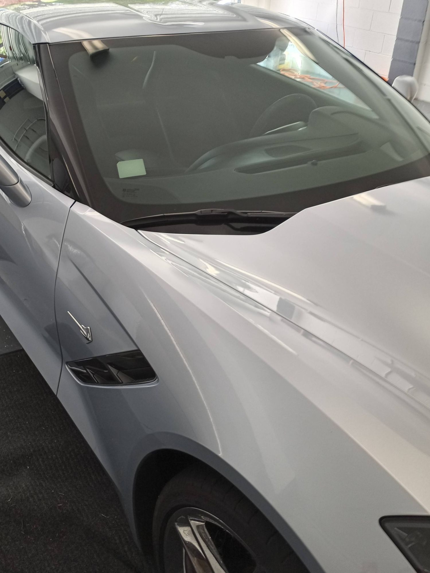 A silver sports car is parked in a garage.