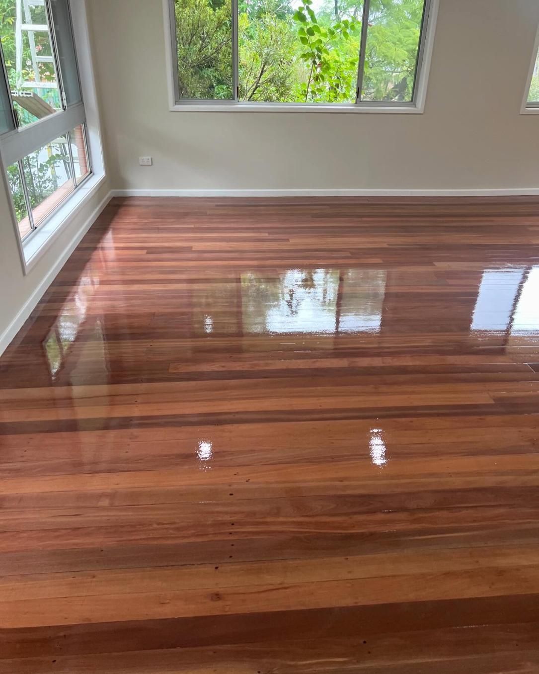 A Living Room With a Wooden Floor and Two Windows — Timberfection Queensland in Yatala, QLD
