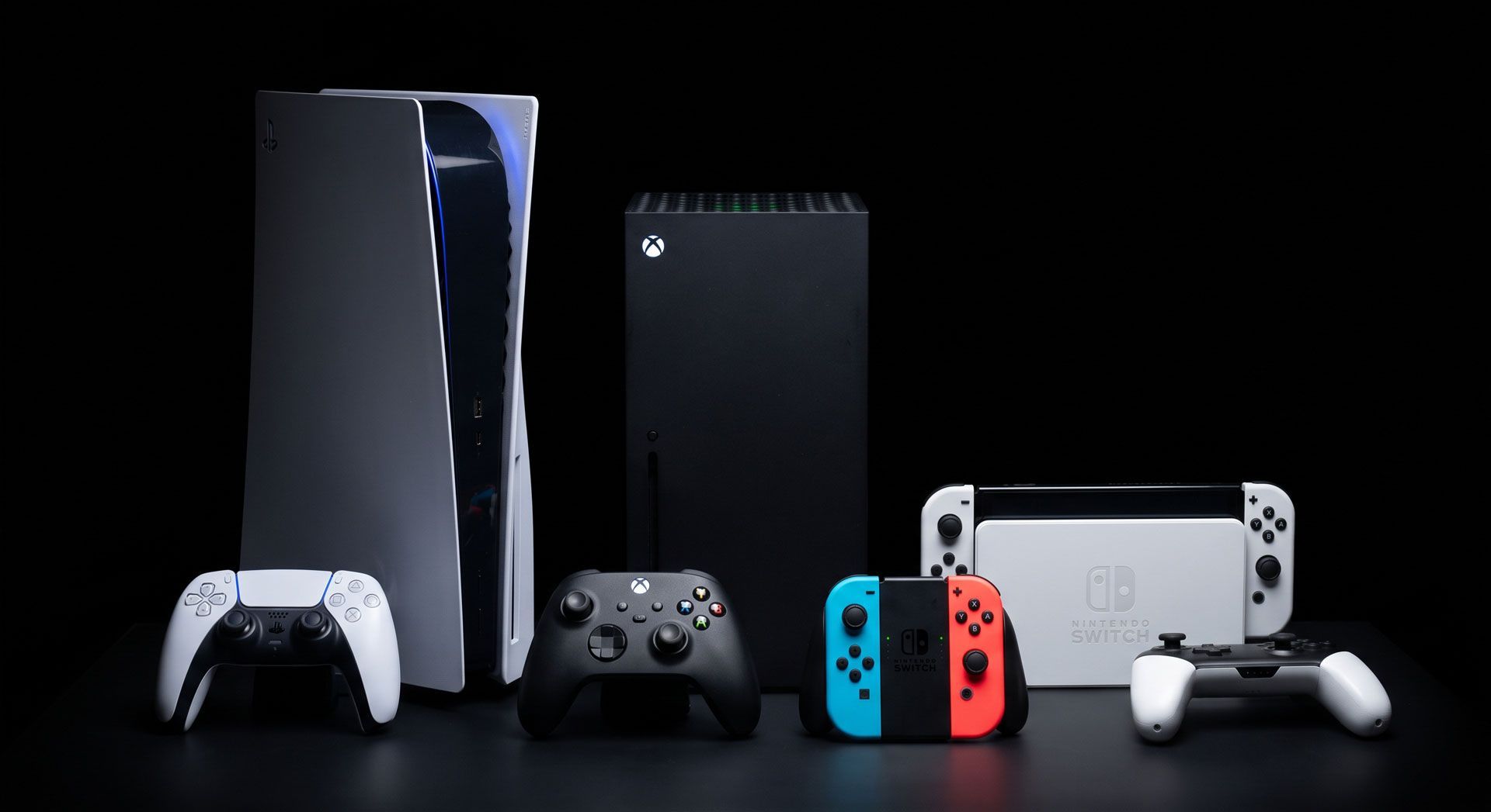 PlayStation consoles and controllers lineup on a black background, including PS5 and handheld devices